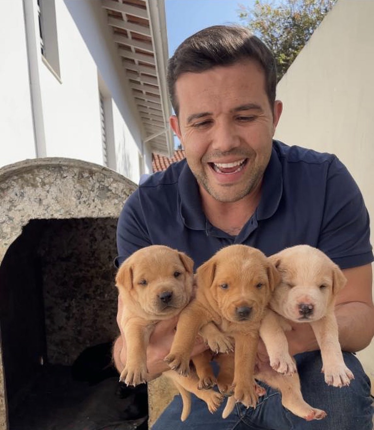 Lucas Cardoso com três filhotes, em uma imagem de apoio à causa animal